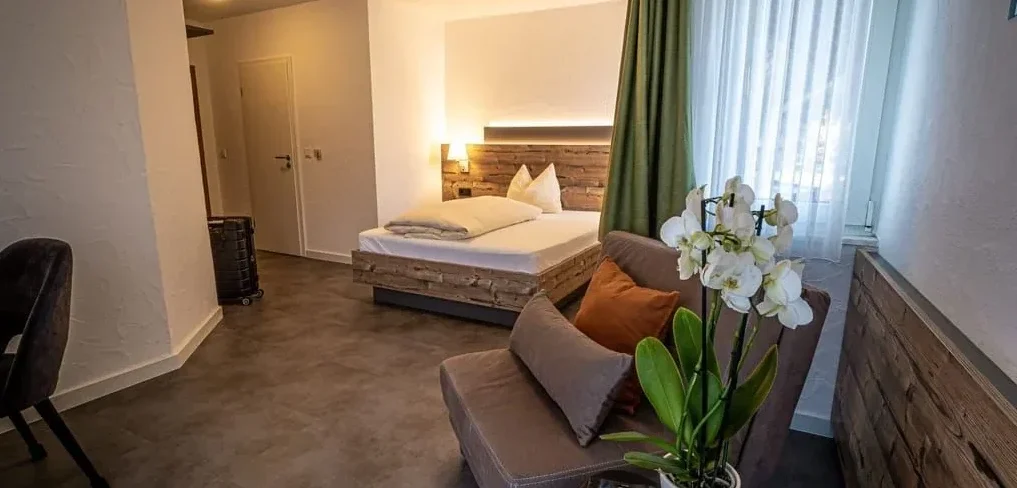 Komfort Zimmer - Massivholzbett und gemütlicher Sitzbereich